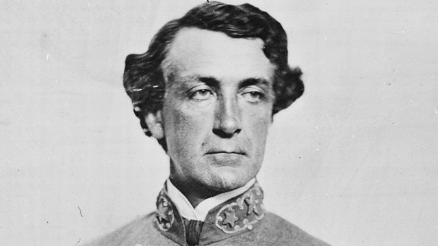 A black and white image of Martin Smith in Confederate generals uniform holding his sword.