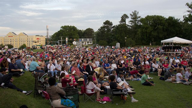 A large group of visitors sitting at a concert.