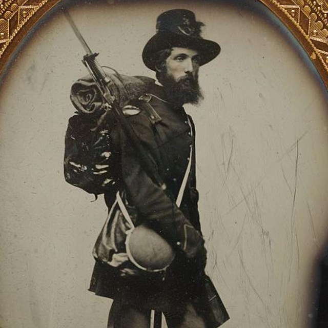 A Union soldier with his musket slung over his shoulder carrying a knapsack, canteen and haversack.