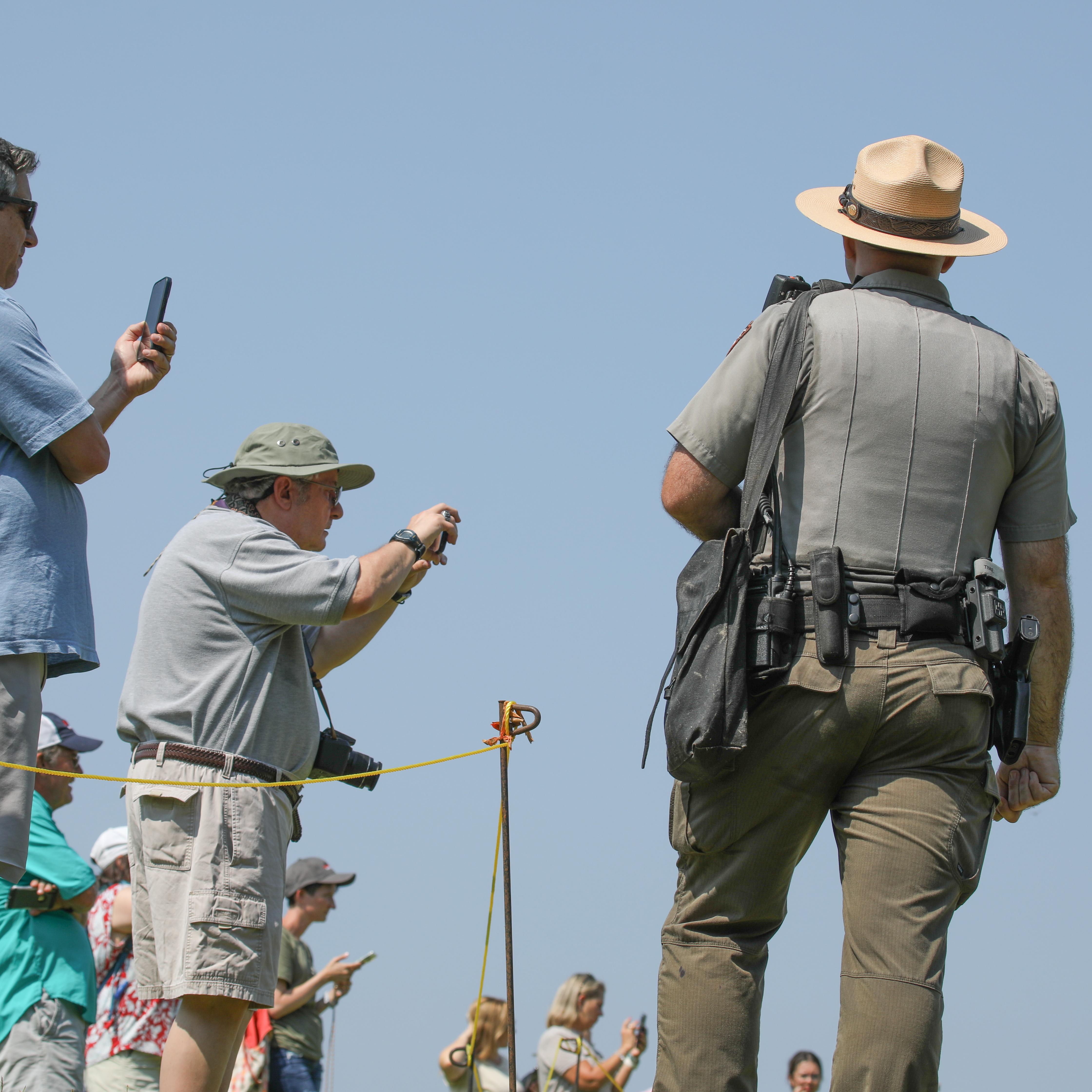 A Park Ranger monitors a crowd of visitors.