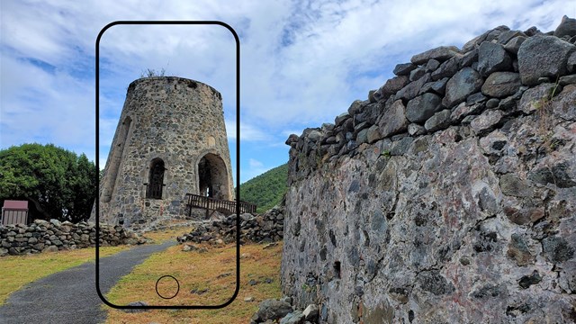 A black smartphone-shaped frame focuses on a stone masonry windmill, part of a sugar plantation ruin