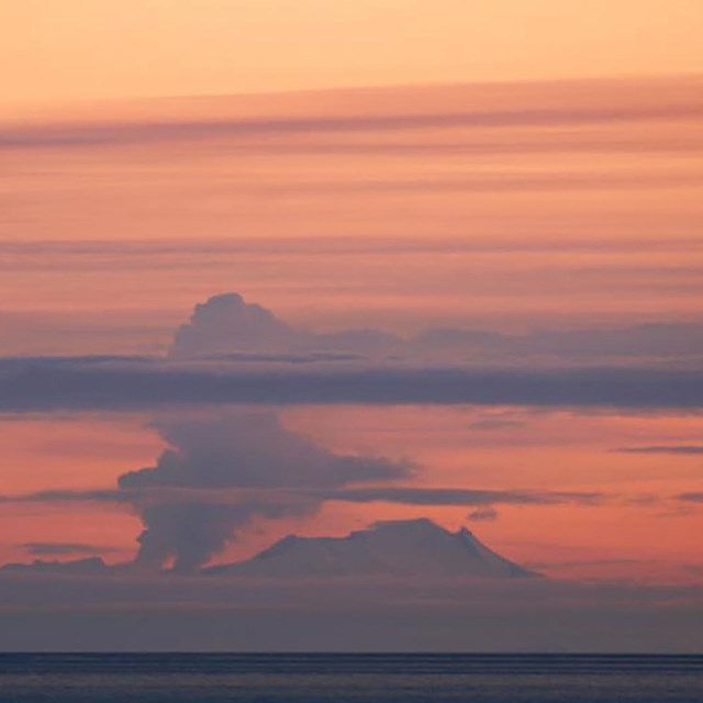 distant view of an erupting volcano at dusk