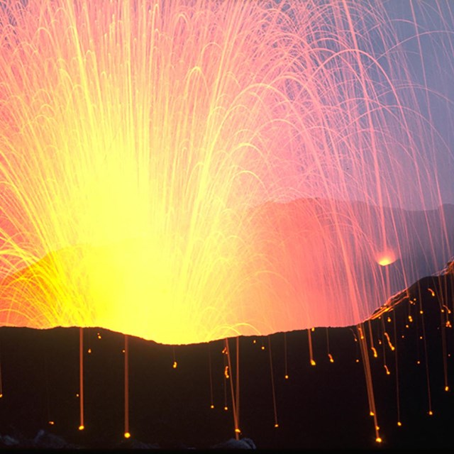 volcanic eruption time lapse with firey projectiles creating bright arcs of light