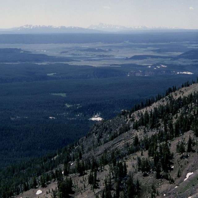 photo of a large flat valley with mountains in the foreground and in the distance