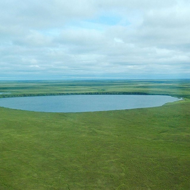 water-filled maar appears as a lake in a green field