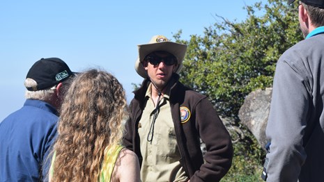 A volunteer leads a group of visitors.