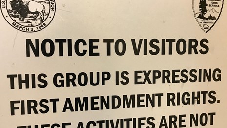 A sign giving notice to visitors that a group is expressing their first amendment rights.