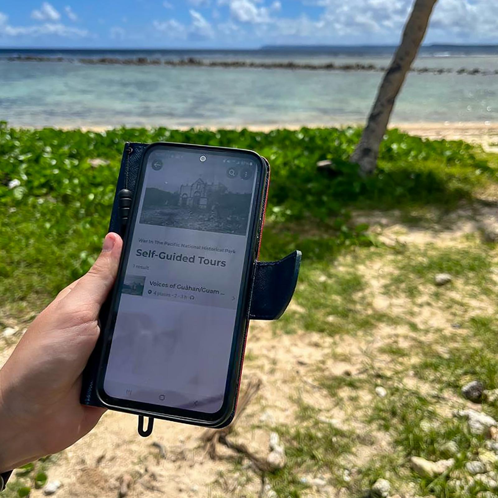 A phone open to the self-guided tour page for War in the Pacific National Historical Park. 