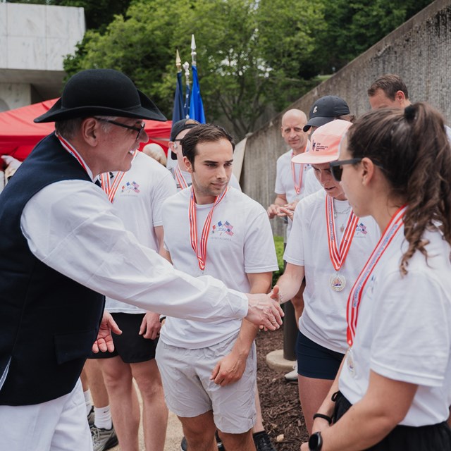 Volunteer passes out trail medals to runners 