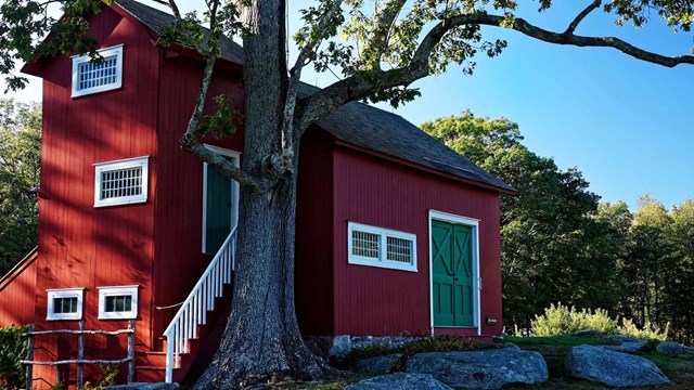 A red building with a green door and white trim.