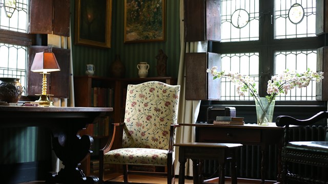 A living room with dark wood furniture and stained glass windows.