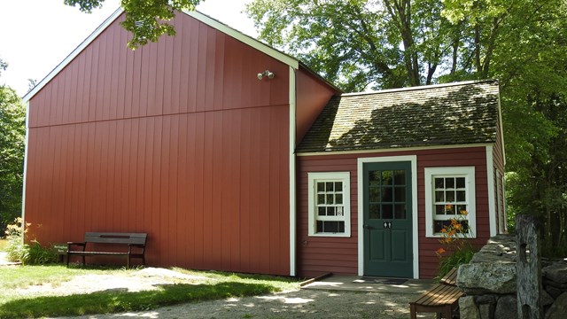 A red building with white trim and a white door.