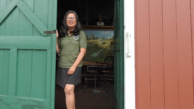 Weir Farm volunteer stands in the doorway of the Weir Studio, ready to provide a tour to visitors