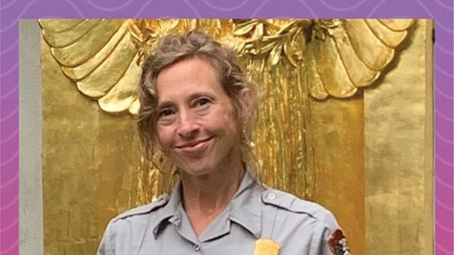 A ranger standing in front of a golden statue.