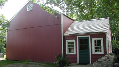 A red building with white trim and a white door.