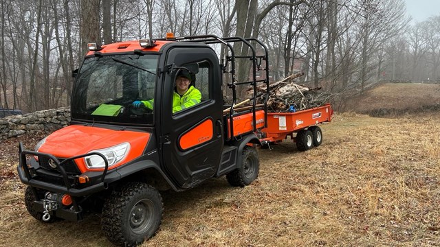 Maintenance Worker Driving Tractor At Weir Farm
