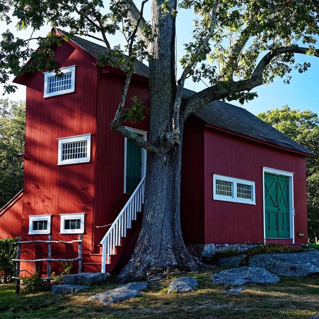 A red building with a green door and white trim.