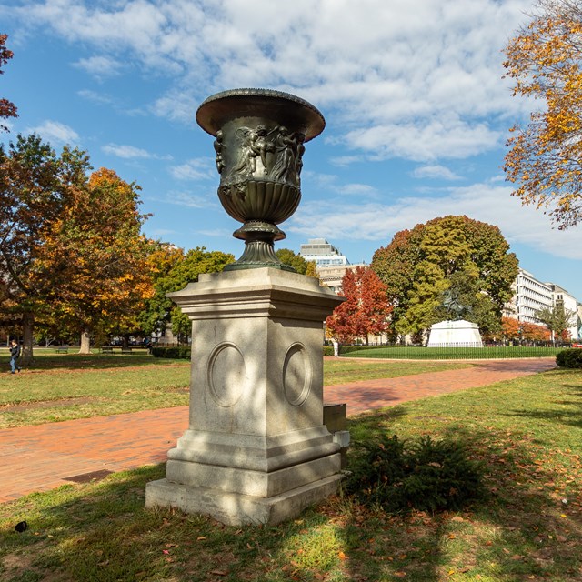 A bronze urn atop a stone plinth in Lafayette Park.