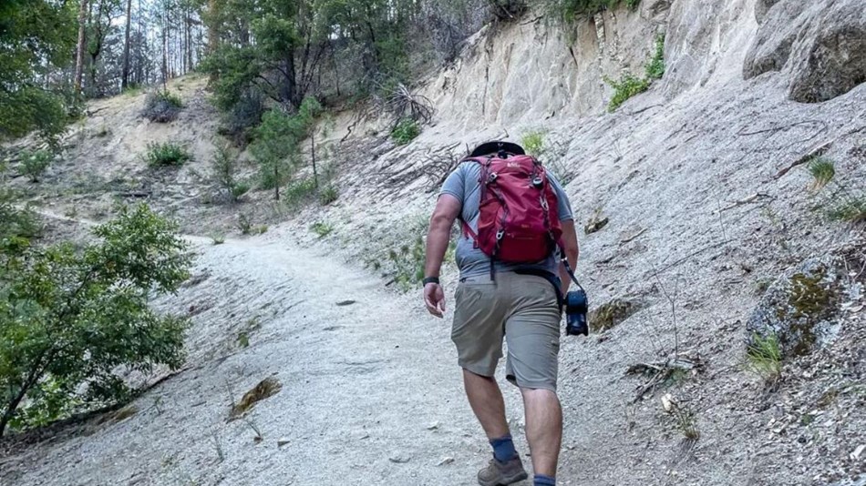 male hiker in shorts hiking uphill