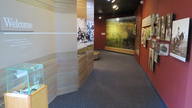 A hallway leading to museum exhibits further down the hall, on the wall is written "Welcome"