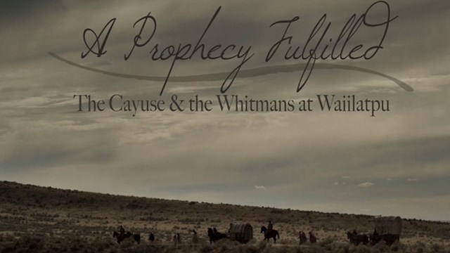 A wagon train is moving across a tallgrass field. The words "A Prophecy Fulfilled" appear in the sky