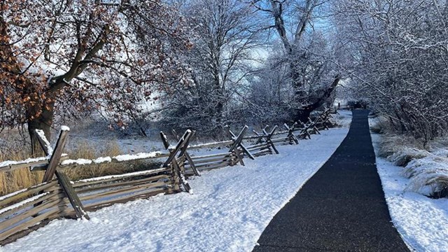 A clear pathway up a gradual slope with surrounding land covered by snow and ice