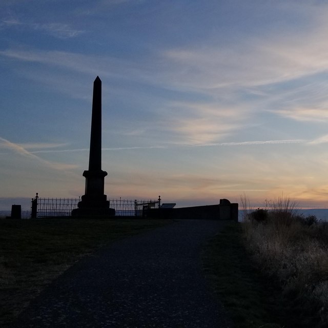 Whitman monument silhouetted against the sunset