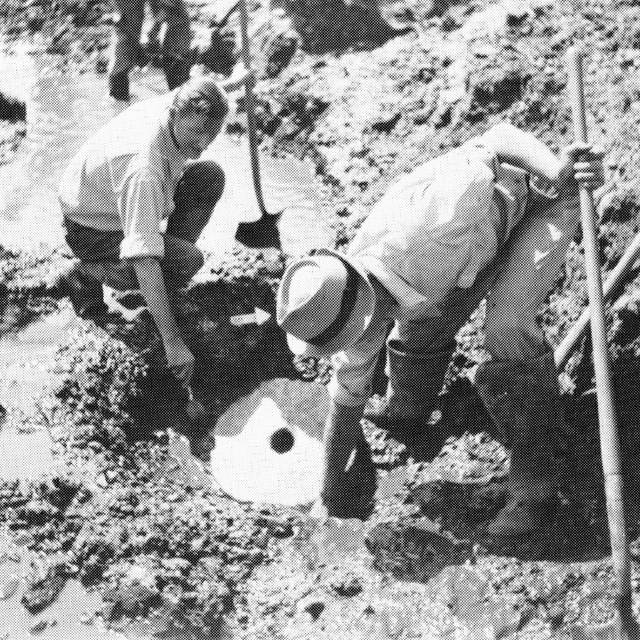 black and white photo of archeologists digging