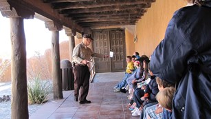 Children sitting on benches in courtyard.