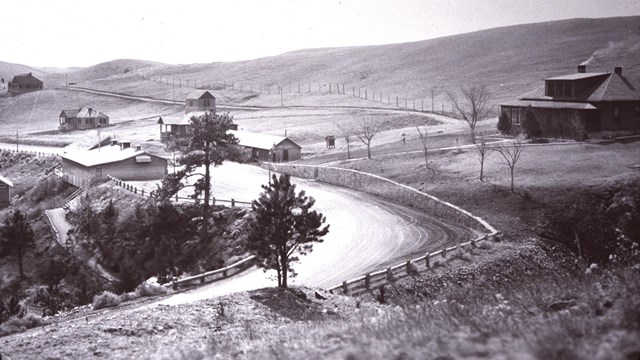 black and white photo of the parking lot, visitor center, and several park houses in 1932