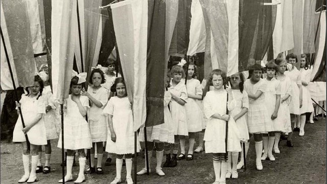 Image of young girls holding banners for suffrage. From cover of Junior Suffragist book