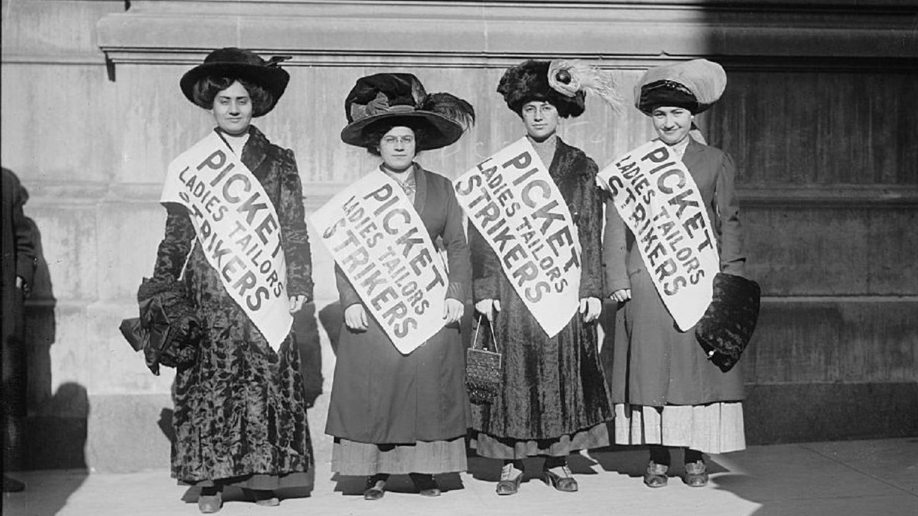 Four women wearing picket signs.