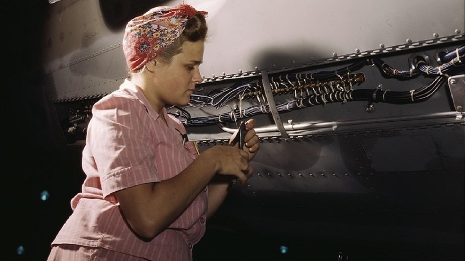 A woman works on the wiring in an airplane, courtesy Library of Congress