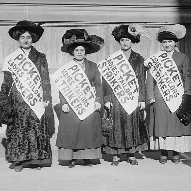 Four women wearing picket signs.