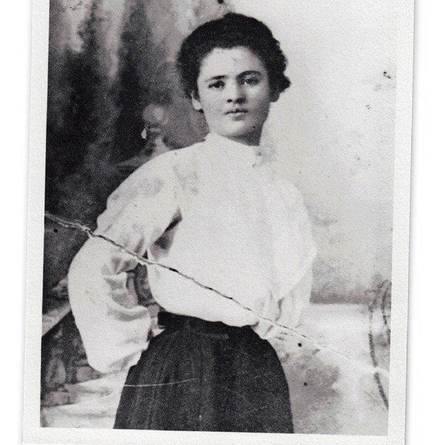 Woman wearing white blouse and skirt.