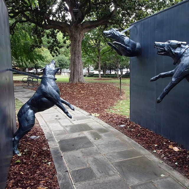 statue of attacking dogs, monument to those attacked by police dogs in Birmingham. By Alacoolwiki CC
