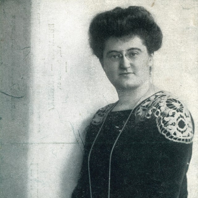 Portrait of woman dressed in black with hands on a book