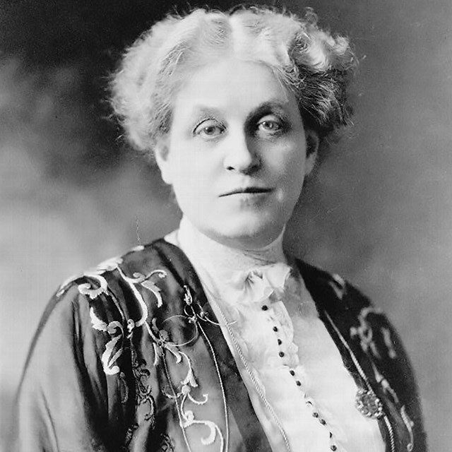 Woman wearing jacket and blouse with short gray hair