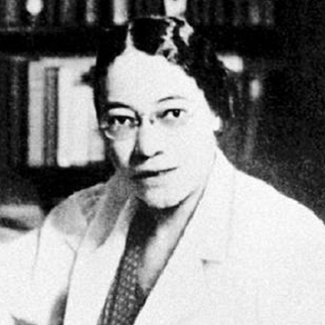 Head and shoulders portrait of a woman wearing a lab coat.