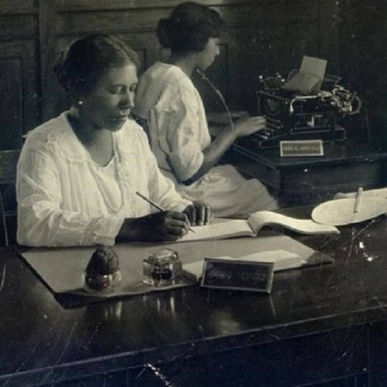 Women sitting and writing. NPS photo. 