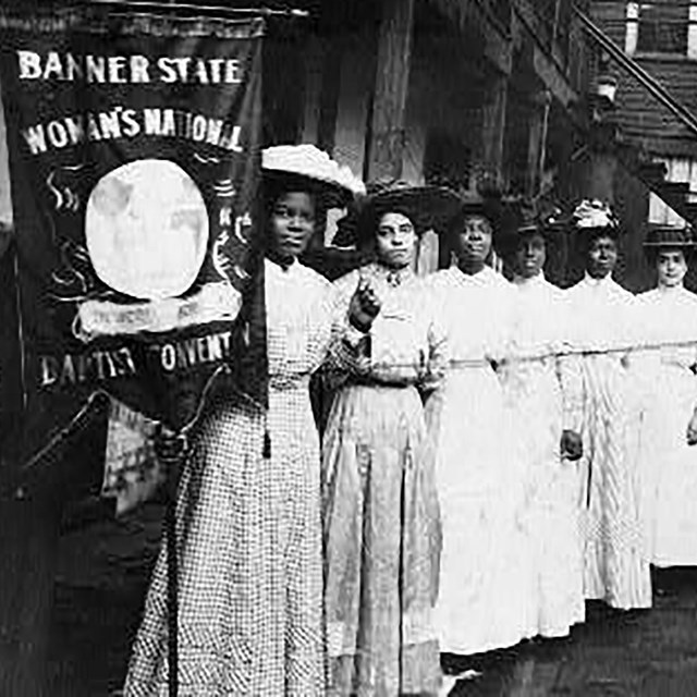 Nannie Helen Burroughs and other women holding a suffrage banner. LOC photo