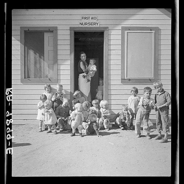 Black and white image of children outside a building
