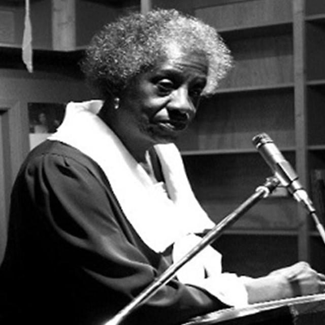 Black and white photo of Unita Blackwell standing at a podium