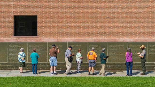Visitors learning about Declaration of Sentiments at the Waterwall in Declaration Park.