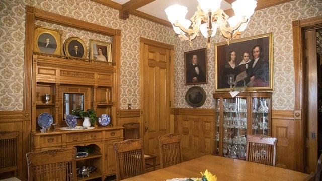 A wood-paneled dining room with antique decorations.