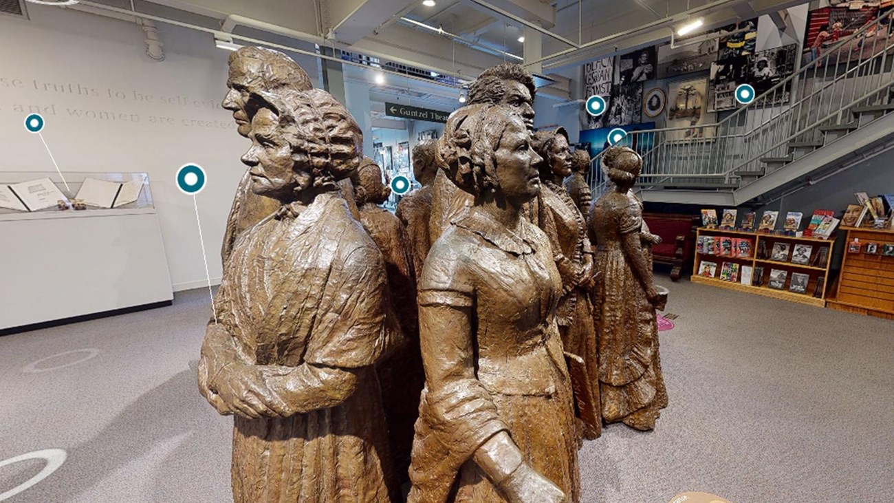 A group of bronze statues stand in a large room.