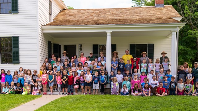 A large group of students pose on the Stanton House porch