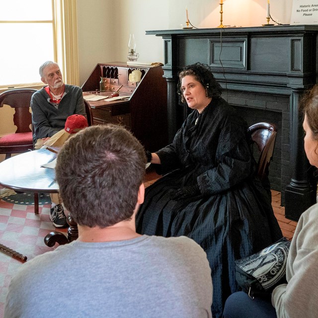 A living historian dressed as Elizabeth Cady Stanton sits and speaks to visitors.