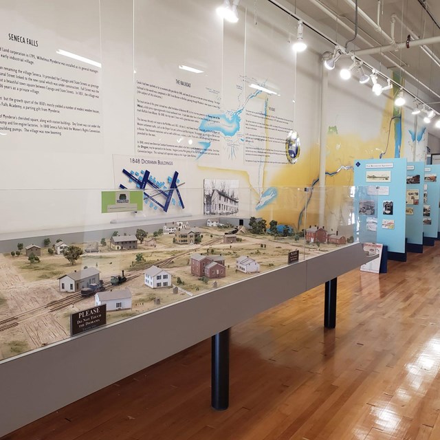 A room with a display case showing a diorama of a town