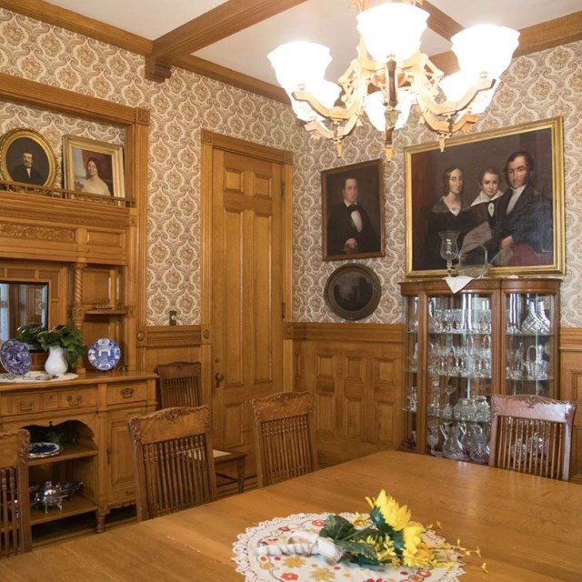 A wood-paneled dining room with antique decorations.